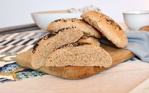 A pile of four döner bread rolls, with one bread cut in half