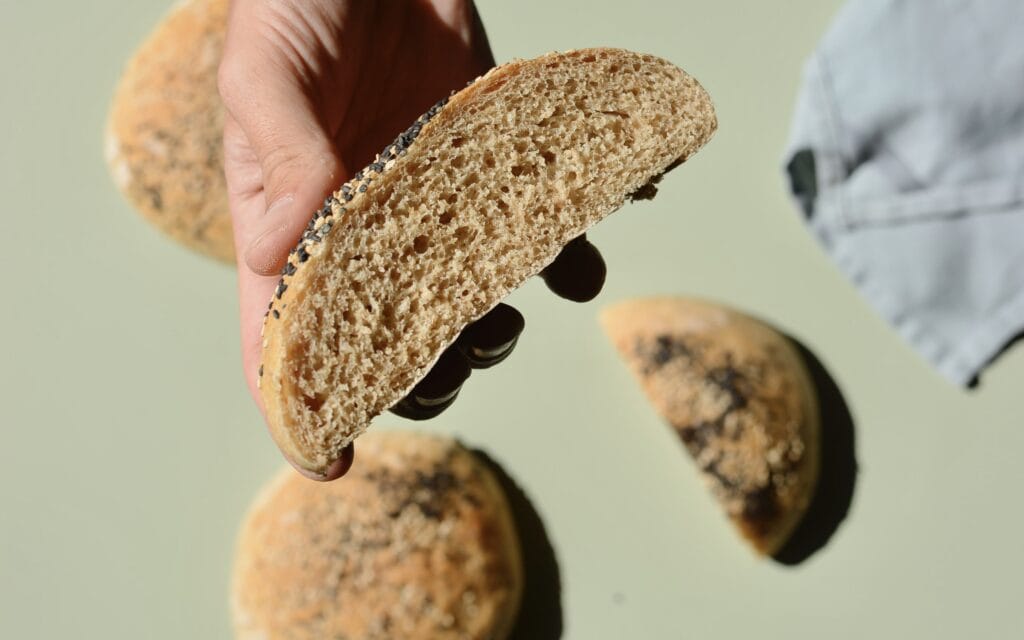 A photo of a hand holding a Döner bread cut in half
